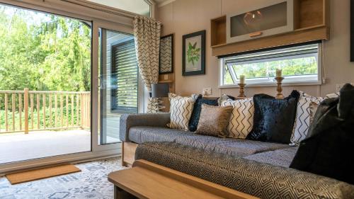 a living room with a couch and a sliding glass door at Waterfoot Park in Pooley Bridge