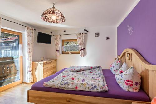 a bedroom with a bed with purple walls at Ferienwohnung Amethyst in Mittenwald