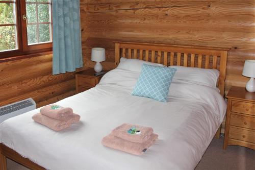a bedroom with a bed with towels on it at Osiers Country Lodges in Diss