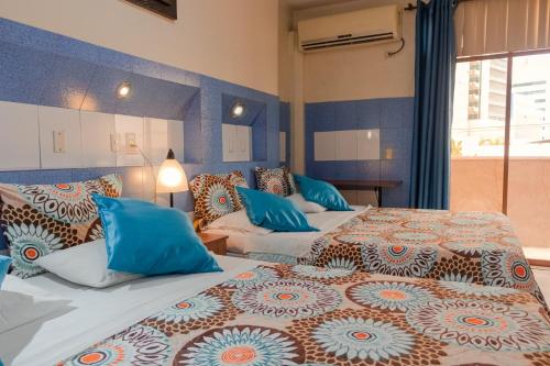 two beds in a room with blue and orange at Hotel Livingston Inn in Guayaquil