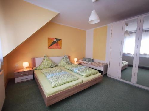 a bedroom with a bed with pillows and a window at Ferienwohnung Zschorlau/Erzgebirge 03771 479123 in Zschorlau
