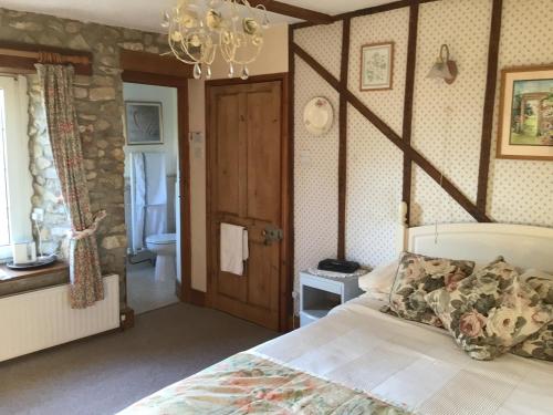 a bedroom with a bed and a bathroom at Barn Park Farm, Bed and Breakfast in Honiton