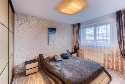 a bedroom with a large bed and a window at Apartment near center in Klaipėda