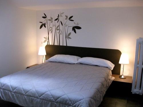 a bedroom with a bed with two lamps and two pillows at Low Cost Ferrara in Ferrara