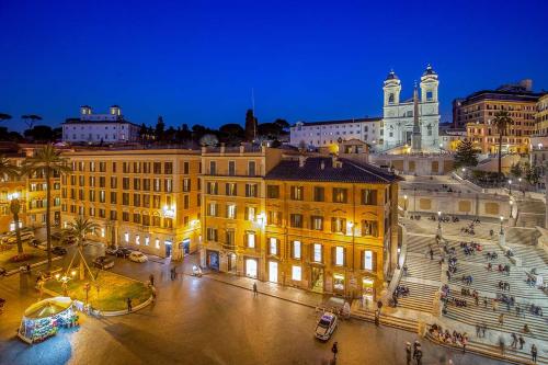 
a city at night with buildings and a clock tower at The Inn at the Spanish Steps in Rome
