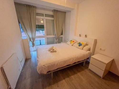 a small bedroom with a bed and a window at Bonito apartamento cerca del puerto in Málaga