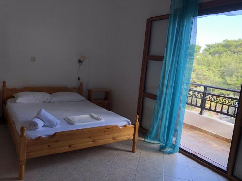 1 dormitorio con 1 cama y vistas a un balcón en Nikos Apartments A3, en Gialiskari