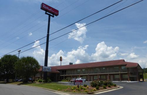 un edificio con un cartel de venta delante de él en Red Roof Inn & Suites Cleveland, TN, en Cleveland
