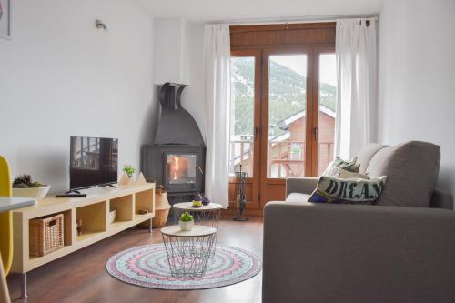 sala de estar con sofá y chimenea en Apartament Ninot Bonito apartamento con vistas a la X de Grandvalira en El Tarter