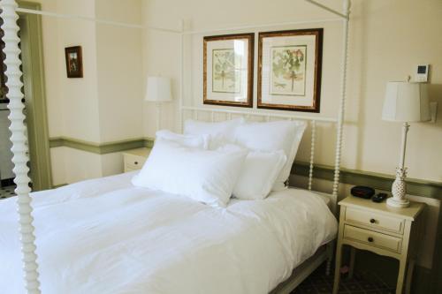 a bedroom with a white bed with white pillows at Mary's Land Farm in Ellicott City