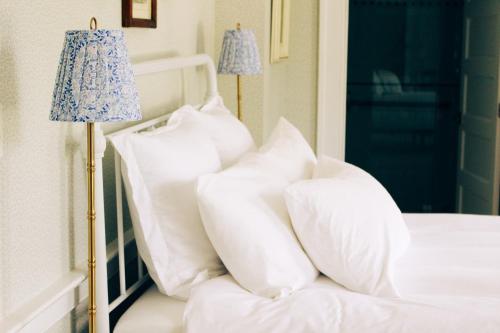 a pile of pillows on a bed with a lamp at Mary's Land Farm in Ellicott City