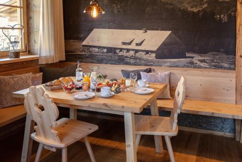 a wooden table with food on it with two chairs at Chalets Alpglück in Oberstdorf