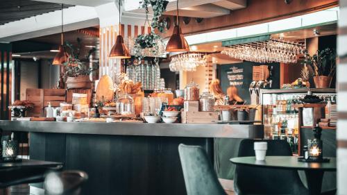 a restaurant with a bar with tables and chairs at Home Hotel Uppsala in Uppsala
