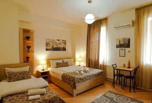 a bedroom with two beds and a table and a desk at Check-In Hotel in Tbilisi City