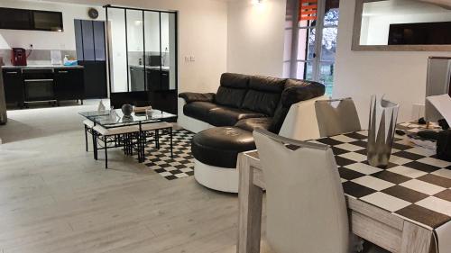 un salon avec un canapé et une table dans l'établissement Grande maison avec jardin, animaux,au calme, à Yviers