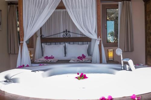 a bedroom with a bed with a bath tub at Lissiya Hotel in Faralya