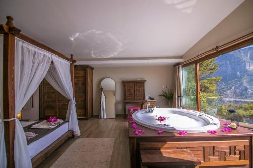 a bathroom with a large tub and a large window at Lissiya Hotel in Faralya