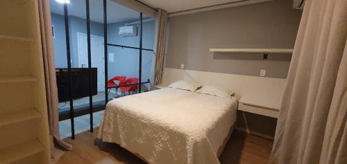 a small bedroom with a bed and a large window at Yes Vancouver Flats in Corumbá