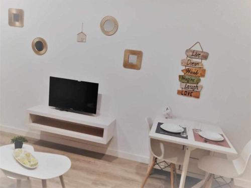 uma sala de estar com televisão numa parede branca em San José Apartamentos Turísticos Miky em Albacete