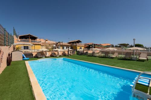 a swimming pool in a yard next to a house at Casa Adara - Heated pool included in San Bartolomé