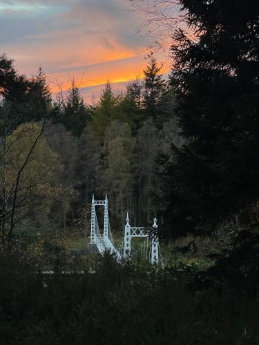 a large white bridge in the middle of a forest at Cambus O' May Traditional Highland Hotel in Ballater