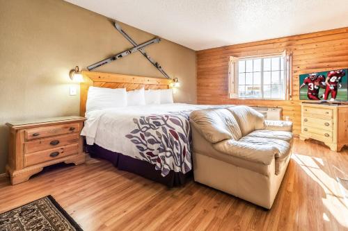 a bedroom with a bed and a couch and a chair at Red Roof Inn & Suites Omaha - Council Bluffs in Council Bluffs