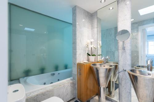 a bathroom with two urinals and a bath tub at STUNNING APARTMENT FIRST LINE MOGAN PORT - GRAN CANARIA STAYS in Puerto de Mogán