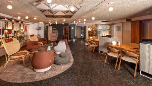 een kamer met stoelen en tafels in een kamer bij Thalazur Royan - Hôtel & Spa in Royan