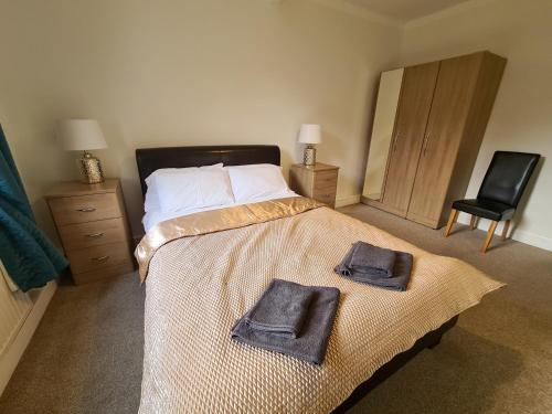a bedroom with a bed with two towels on it at Lovely self-catering apartment in city centre in Dumfries