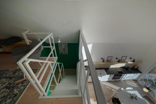uma escada num quarto com uma parede verde em Holzhaus Sikonda em Komló