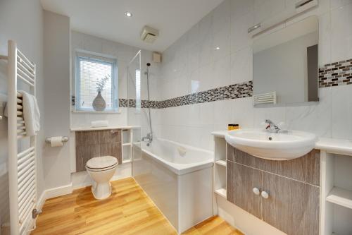 a white bathroom with a sink and a toilet at Swan Apartments 2A Cosy City Break Staycation in Newcastle upon Tyne