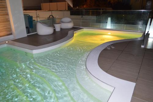 a swimming pool in a bathroom with ailed floor at Hotel Villa Paola in Rimini