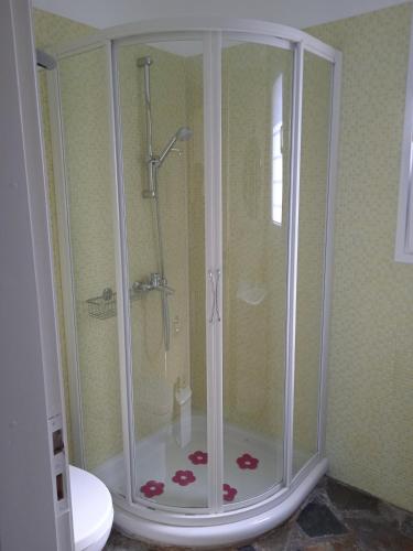 a shower with a glass door in a bathroom at Calma in Perdika
