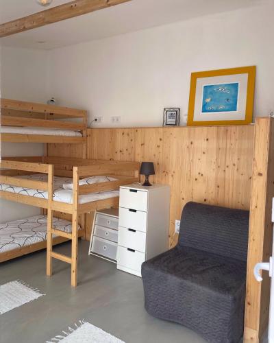 a room with two bunk beds and a chair at Baleal waterfront in Baleal