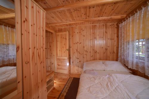 1 dormitorio con 2 camas en una cabaña de madera en Domki Pod Wydmami 40m od plaży en Dźwirzyno