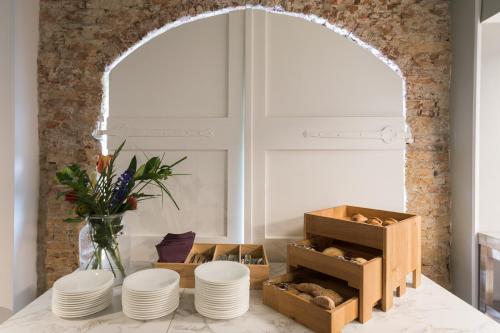 a kitchen with a table with plates and a vase of flowers at Boutique Hotel Rijks I Kloeg Collection in Goes