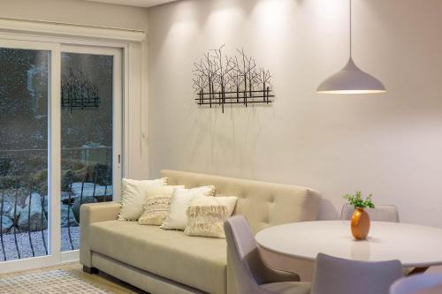 sala de estar con sofá y mesa en Vivendas Do Bosque 106 C - Apartamento em Gramado, en Gramado