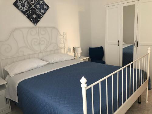 1 dormitorio con cama blanca y manta azul en B&B MimmoSole, en Agropoli
