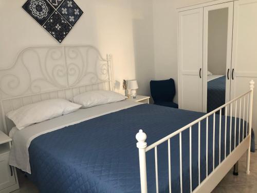 sypialnia z białym łóżkiem i niebieskim kocem w obiekcie B&B MimmoSole w Agropoli