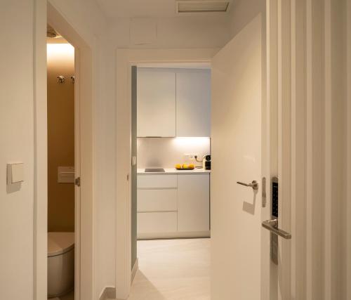 a kitchen with white cabinets and a toilet in a room at CALM SUITES Molino Corteza del Carmen in Granada