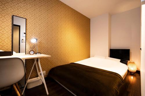 a bedroom with a bed and a desk and a mirror at Apartment Sun Bright - Vacation STAY 89260v in Tokyo