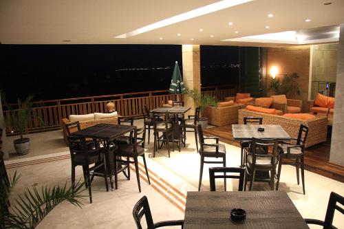 a restaurant with tables and chairs and a couch at Garden of Eden Complex in Sveti Vlas