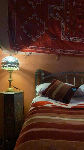 a bedroom with a bed and a lamp on a table at Riad Al Nour in Marrakech