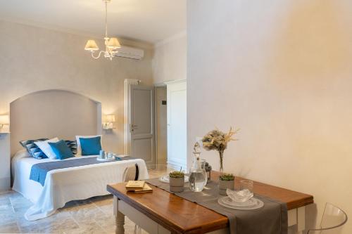 a bedroom with a bed with blue pillows and a table at Beatabb in Guardistallo