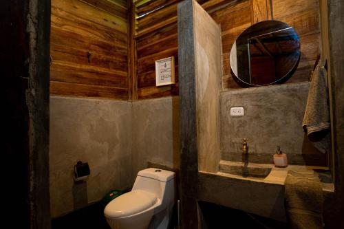 a bathroom with a toilet and a mirror at Casa Chapolin Boutique Guesthouse in Palomino