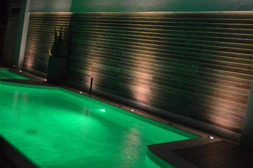 a swimming pool in front of a window with blinds at Hotel Villa Paola in Rimini