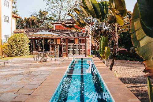 a swimming pool in front of a house at Pousada d'Oleo de Guignard in Tiradentes