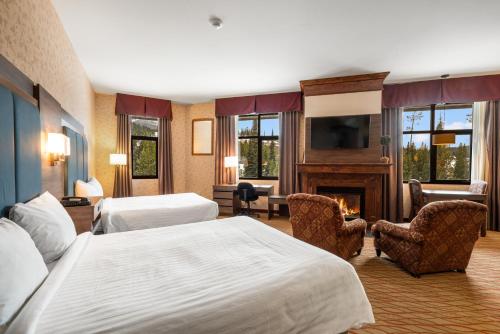 une chambre d'hôtel avec un lit et une cheminée dans l'établissement The Lodge at Big Sky, à Big Sky