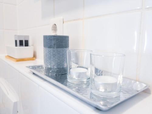un plateau avec trois verres et une bougie sur un comptoir dans l'établissement Wohlfühl-Oase mitten in der Stadt - Garten, Grill, Netflix und Drucker, à Leipzig