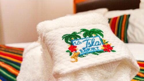 a white pillow with a hotel sign on it at La Isla Resort in Caye Caulker